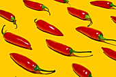From above of fresh ripe chili peppers on yellow background