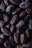 Full frame background top view of pile of appetizing dried date medjoul fruits arranged on surface