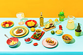 From above assorted traditional Mexican dishes and drinks placed on blue table near yellow wall