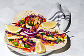 Hausgemachte mexikanische Tacos mit frischem Gemüse und Hühnchen mit starkem Licht auf weißem Hintergrund. Gesundes Essen. Typisch mexikanisch