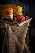 Colorful French macaroons with various fillings placed in a tray on wooden table