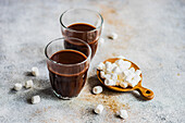 Hot chocolate with mini marshmallow in the glass on concrete background