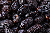 Full frame background top view of pile of appetizing dried date medjoul fruits arranged on surface