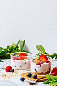 Delicious homemade yogurt with strawberries, berries and cereals on white background