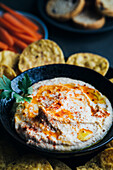 Leckerer Hummus mit Paprika, Olivenöl und etwas Brot zum Dippen