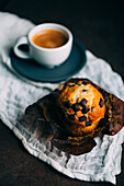 Chocolate muffins and coffee cup on dark background