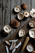 From above shot of wooden board with bowl full of shiitake mushrooms and eggplant on top