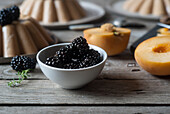 Closeup of served vegan panna cotta with peach and shiny sweet blackberry