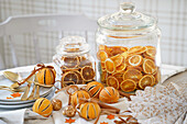 Dried orange slices in glass jars next to Christmas table decorations