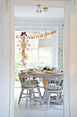 Table setting in a bright dining room with garland of dried orange slices