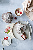 Heart-shaped chocolate cake with vanilla cream and raspberries