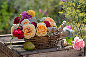 Bouquet of roses (pink), dahlias (Dahlia), wild carrot in wicker basket