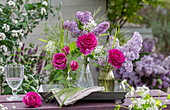 Bouquet of lilac (Syringa Vulgaris), rose (Rosa) 'Fräulein Maria', wild garlic flowers and woodruff in vases on garden bench