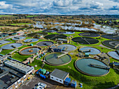 Aerial view of sewage farm on bank of flooded River Avon, UK