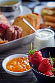 Sweet breakfast with pastries, jam and strawberries