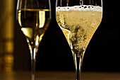 Two glasses of sparkling wine against a dark background