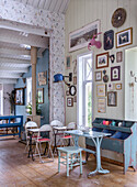 Country-style room with blue storage unit and picture gallery on wooden paneled walls