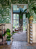 Living area with jungle wallpaper, stone floor and plants