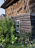 Alter Holzschuppen mit Heuballen und Bauerngarten