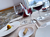 Elegante Tischdekoration mit Weingläsern und Gourmet-Häppchen
