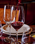 Einschenken von Rotwein in Weingläser