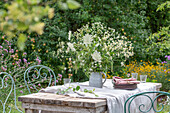 Table setting with a bouquet of wild carrot (Daucus carota) and wild herbs in the garden