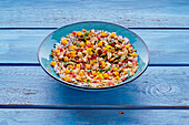 Colourful superfood bowl with pomegranate, mango and nuts