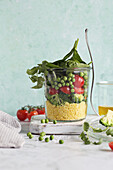 Salad in a jar with couscous, vegetables and spinach