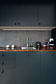 Modern kitchenette with dark cabinets