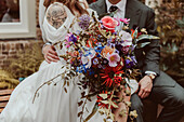 Bride with fancy bouquet and groom in suit at wedding reception