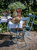 Garden seating area with blue chairs, straw hat and wicker basket