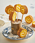 Pumpkin sponge roll on a stick with hazelnuts and cinnamon