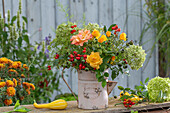 Autumn bouquet of rose hips (Rosa Canina), roses, hydrangea, ornamental pumpkin, fennel blossoms, asparagus, harvest thanksgiving