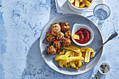 Meatballs with capers, chips and ketchup