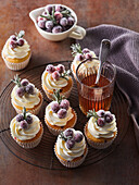 Cupcakes with cream, cranberries and rosemary