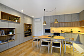 Modern kitchen in wood and concrete look with dining table and integrated shelving system