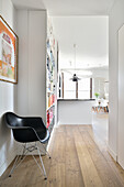 Hallway with wooden floor, designer chair and bookshelf