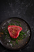 Raw tuna steak on rock samphire with sea salt and spices