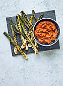 Grilled spring onions with tomato and paprika sauce