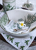 Table decoration with green and white embroidery, daisies in miniature cups