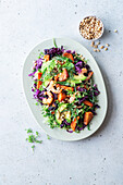 Colourful salad with prawns, avocado, red cabbage, sweet potato and pine nuts