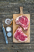 Barbecued ox chops next to beer and barbecue tongs