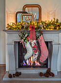 Fireplace decorated for Christmas with stockings and fir branches