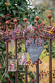 Herz an Gartenzaun hängend mit Wildem Wein und Windlichtern im Herbst