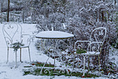 Snow in the garden with a snow-covered table and chairs