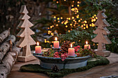 Advent arrangement made of ceramic with pink pepper berries, pine cones