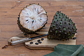 Soursop (Annona muricata) cut open on a chopping board, close-up