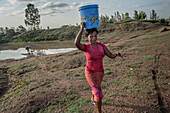 Women carrying water on her head, Kenya