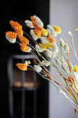 Dried flower bouquet in orange, yellow and cream in focus