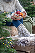 Frau hält weihnachtlichen Teller mit Zimtsternen, Äpfeln und Mandarinen